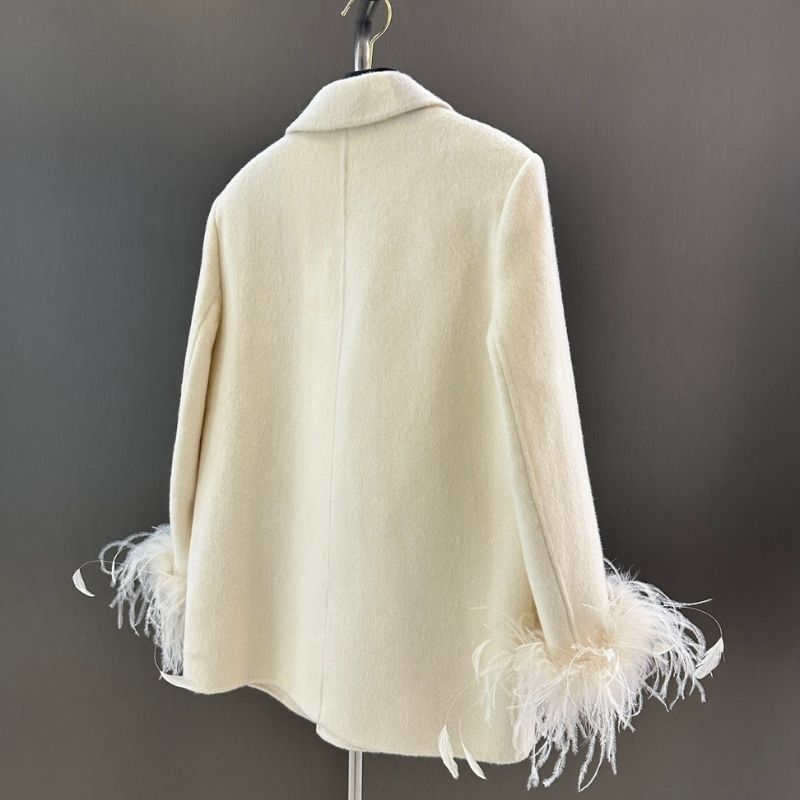 Chanel-style double-breasted blazer with feather cuffs.
