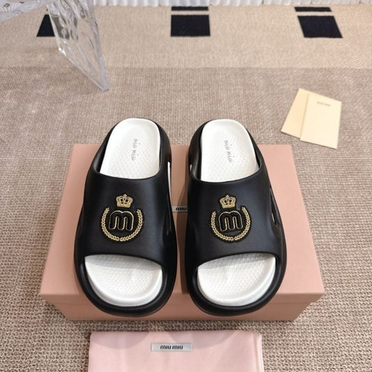 Miu Miu "Slides" sandals with a gold-tone emblem.