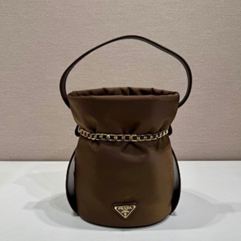 Prada Arqué Re-Nylon and Leather Bucket Bag in a rich cocoa brown.