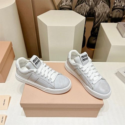 Miu Miu "Bleached Leather" sneakers in white.