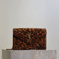 Saint Laurent Cassandre Envelope Chain Wallet with a leopard print.