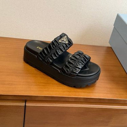 Prada Matelassé Nappa Leather Flatform Slides in black.