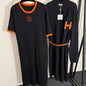 black t-shirt dress and long cardigan set with orange trim and "H" logos.