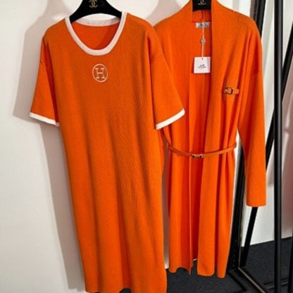 black t-shirt dress and long cardigan set with orange trim and "H" logos.