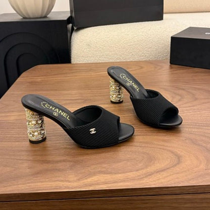 Chanel Ribbed Knit Open-Toe Mules in black.