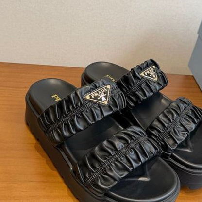Prada Matelassé Nappa Leather Flatform Slides in black.