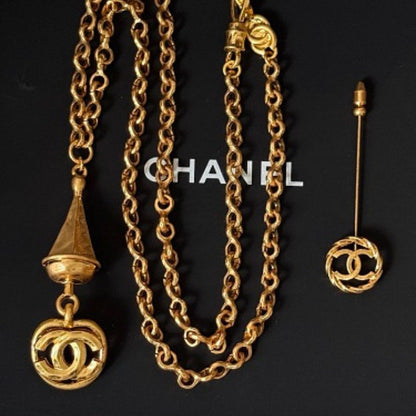 Chanel lion and coin jewelry resting on a black Chanel gift box.